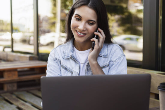 attractive-business-woman-working-in-cafe-on-open-terrace-sitting-in-front-of-laptop-talking-on-the-phone - Merlin - Elektronika Procesor Core i7 o czterech rdzeniach to też istotna zaleta Toshiba Portege X30L-G, bo ten plus znaczy bardzo wiele w przypadku lekkiego laptopa. atutem tego procesora jest jego elektroniczna żywotność, czyli nawet po tych czterech latach od zakupu działa tak jak nowy